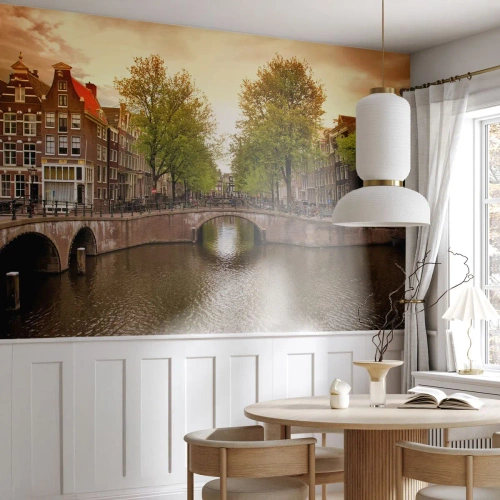 Fotomurali Premium Sand - Un ponte e un canale ad Amsterdam circondati da case e alberi - 100x70cm - In barca o in bicicletta? - Decorazione murale moderna per soggiorno e camera da letto ARTTOR