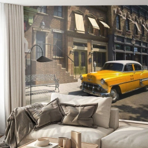 Fotomurali Premium Sand - Un taxi giallo classico sullo sfondo di una città retrò - 100x70cm - Tanto tempo fa in America - Decorazione murale moderna per soggiorno e camera da letto ARTTOR