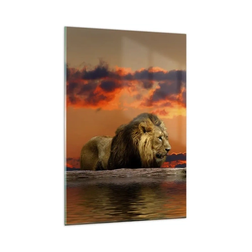 Quadro su vetro - Un leone riposa in riva all'acqua al tramonto, con un cielo spettacolare. - 80x120cm - Il re della natura - Decorazione murale moderna per soggiorno e camera da letto ARTTOR