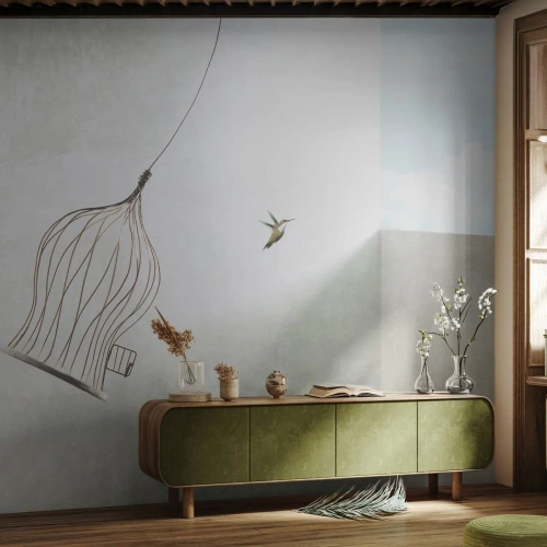 Fotomurali Standard Eco - Un colibrì in volo con una gabbia aperta contro il cielo - 100x70cm - Nel proprio elemento - Decorazione murale moderna per soggiorno e camera da letto ARTTOR