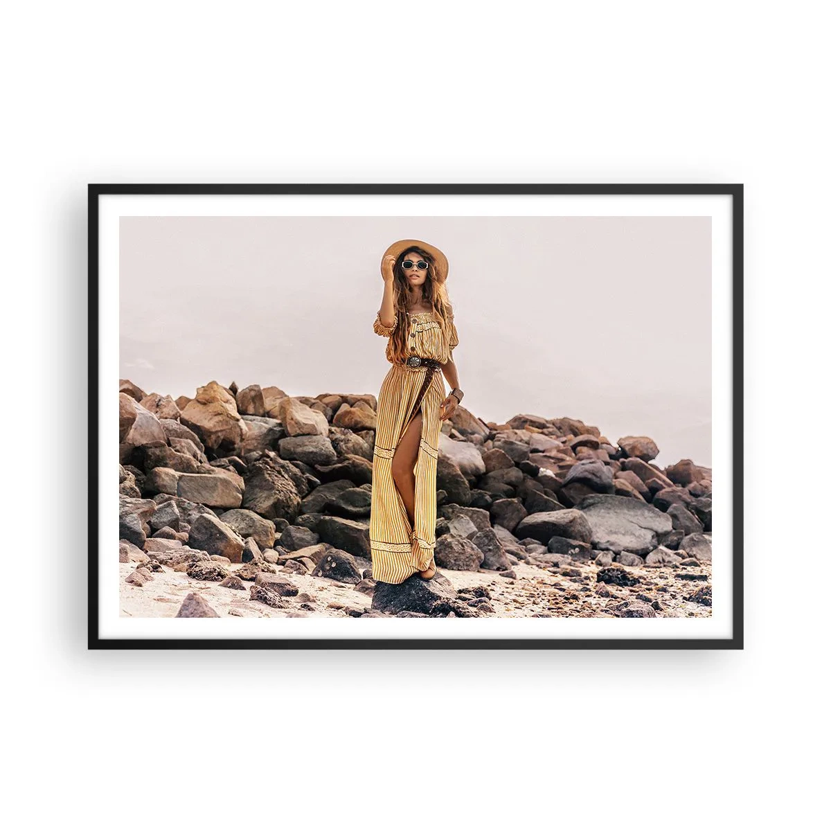 Poster in cornice nera - Una donna in stile boho sullo sfondo di una spiaggia rocciosa - 100x70cm - La magia delle pietre - Decorazione murale moderna per soggiorno e camera da letto ARTTOR