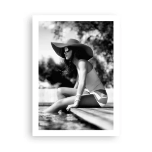 Poster - Una fotografia in bianco e nero di una donna seduta in riva all'acqua, con indosso un cappello. - 50x70cm - Sogno estivo - Decorazione murale moderna per soggiorno e camera da letto ARTTOR