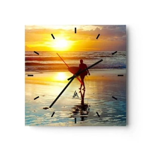 Orologio da parete - Orologio in Vetro - Un surfista cammina sulla spiaggia al tramonto con una tavola in mano. - 30x30cm - Il ritorno del guerriero - Decorazione murale moderna per soggiorno e camera da letto ARTTOR