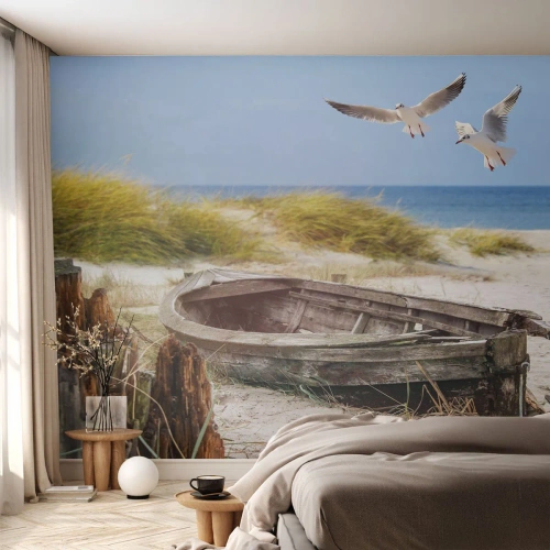 Fotomurali Premium Sand - Una vecchia barca sulla spiaggia con gabbiani sopra - 100x70cm - Bagnate dal vento - Decorazione murale moderna per soggiorno e camera da letto ARTTOR