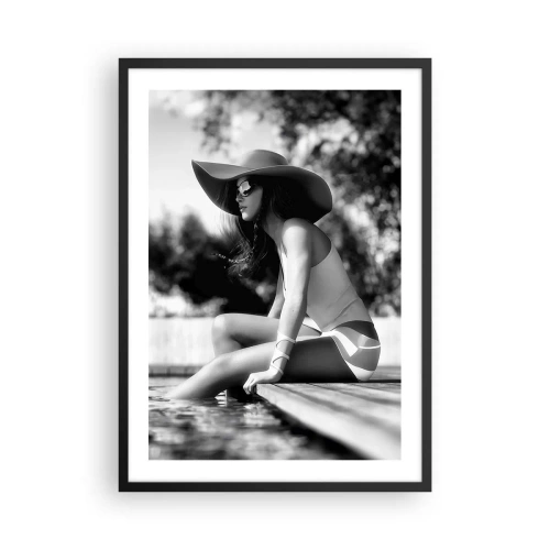Poster in cornice nera - Una fotografia in bianco e nero di una donna seduta in riva all'acqua, con indosso un cappello. - 50x70cm - Sogno estivo - Decorazione murale moderna per soggiorno e camera da letto ARTTOR