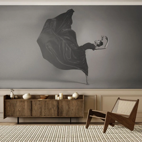 Fotomurali Standard Eco - Una ballerina in abito nero catturata in un movimento dinamico - 100x70cm - Musica alata - Decorazione murale moderna per soggiorno e camera da letto ARTTOR