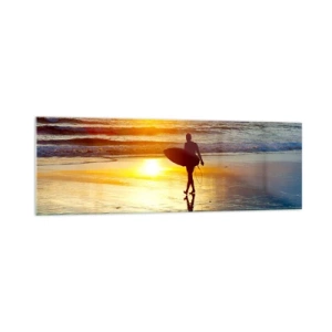 Quadro su vetro - Un surfista cammina sulla spiaggia al tramonto con una tavola in mano. - 160x50cm - Il ritorno del guerriero - Decorazione murale moderna per soggiorno e camera da letto ARTTOR