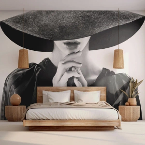 Fotomurali Premium Sand - Donna elegante in nero con un grande cappello in uno scatto glamour - 100x70cm - Bellezza celata - Decorazione murale moderna per soggiorno e camera da letto ARTTOR