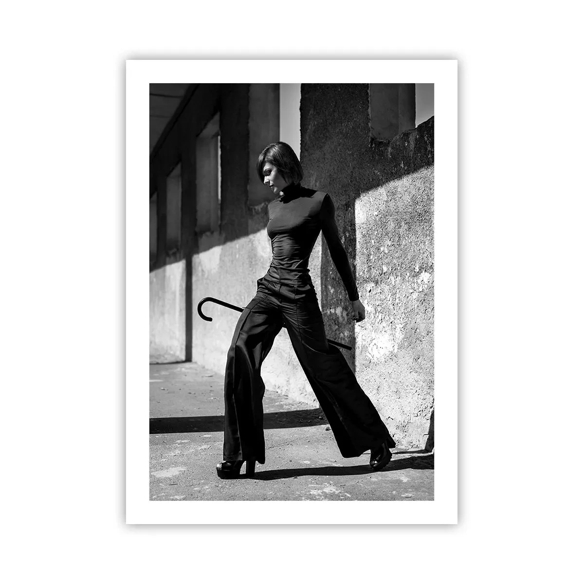 Poster - Una donna in un abito elegante con un bastone sullo sfondo di un'architettura austera - 50x70cm - Eleganza cittadina - Decorazione murale moderna per soggiorno e camera da letto ARTTOR