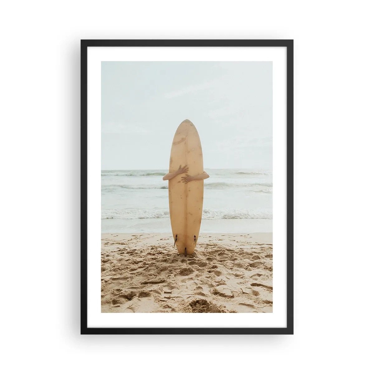 Poster in cornice nera - Una persona che tiene in mano una tavola da surf su una spiaggia, con vista sul mare. - 50x70cm - Amore per le onde - Decorazione murale moderna per soggiorno e camera da letto ARTTOR