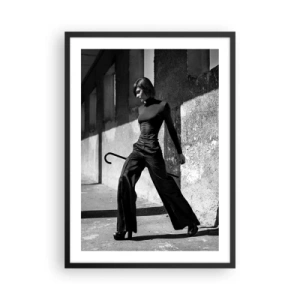 Poster in cornice nera - Una donna in un abito elegante con un bastone sullo sfondo di un'architettura austera - 50x70cm - Eleganza cittadina - Decorazione murale moderna per soggiorno e camera da letto ARTTOR
