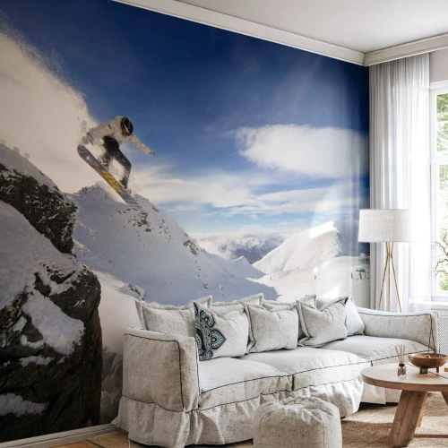 Fotomurali Standard Eco - Uno snowboarder salta da una scogliera contro un paesaggio montuoso - 100x70cm - Libertà senza confini - Decorazione murale moderna per soggiorno e camera da letto ARTTOR