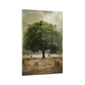 Quadro su vetro - Un albero verde circondato da tronchi d'albero abbattuti contro un cielo nuvoloso - 70x100cm - Ogni speranza - Decorazione murale moderna per soggiorno e camera da letto ARTTOR