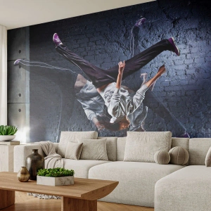 Fotomurali Premium Sand - Un ballerino di breakdance in movimento dinamico contro un muro di mattoni. - 100x70cm - Eroe di strada - Decorazione murale moderna per soggiorno e camera da letto ARTTOR