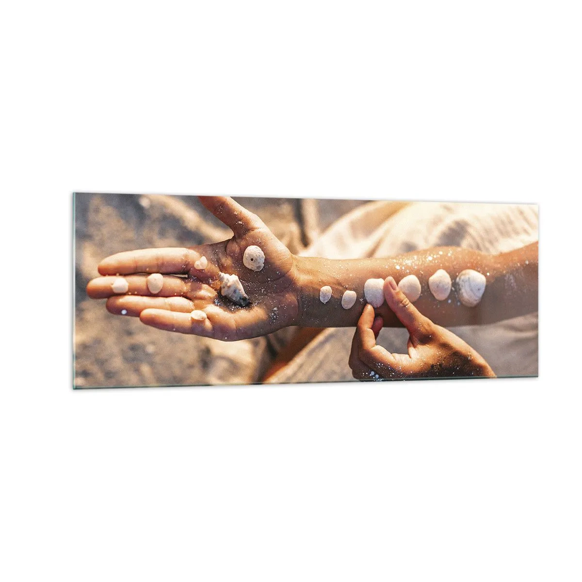 Quadro su vetro - Mani con conchiglie disposte sullo sfondo di sabbia - 140x50cm - La bellezza a portata di mano - Decorazione murale moderna per soggiorno e camera da letto ARTTOR