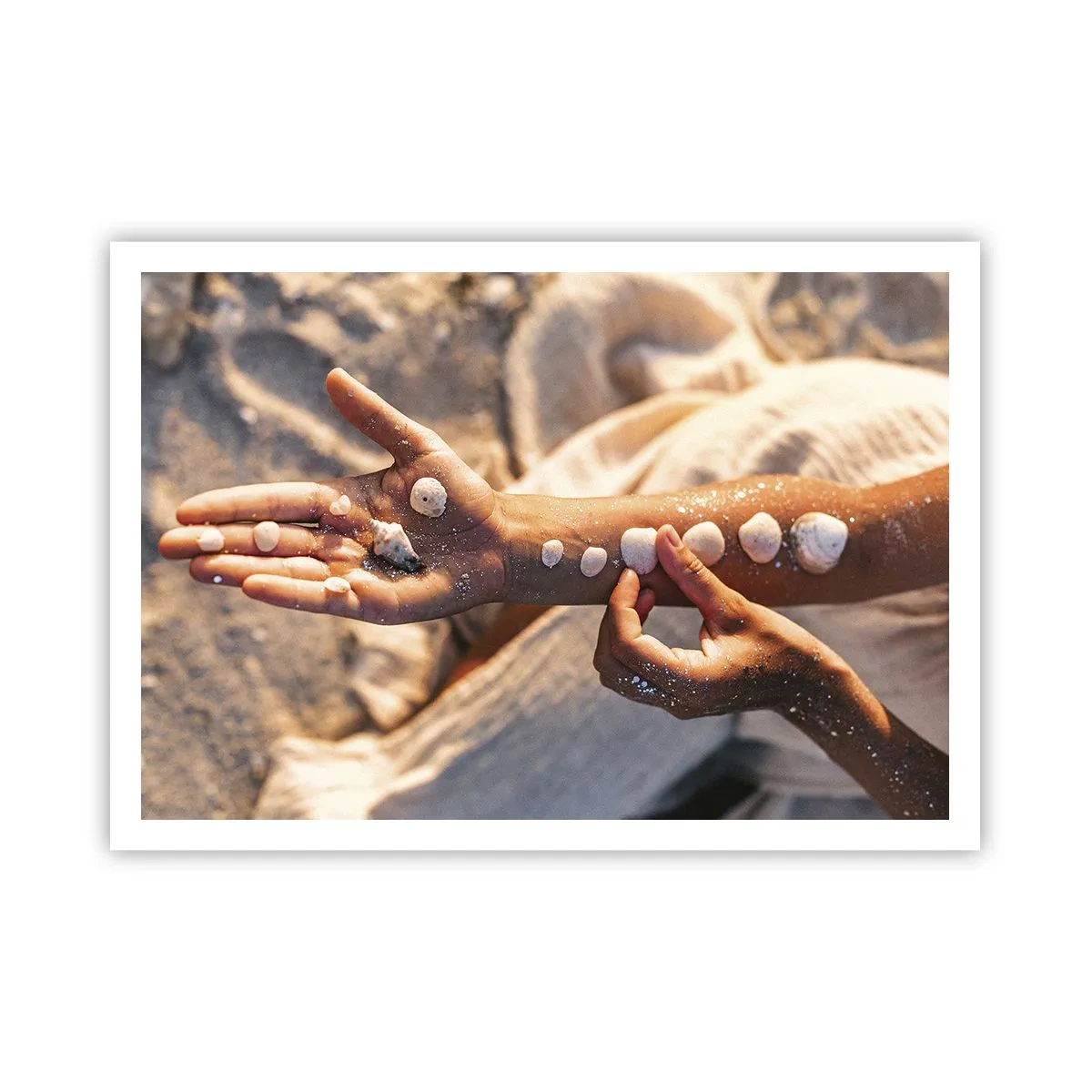 Poster - Mani con conchiglie disposte sullo sfondo di sabbia - 100x70cm - La bellezza a portata di mano - Decorazione murale moderna per soggiorno e camera da letto ARTTOR