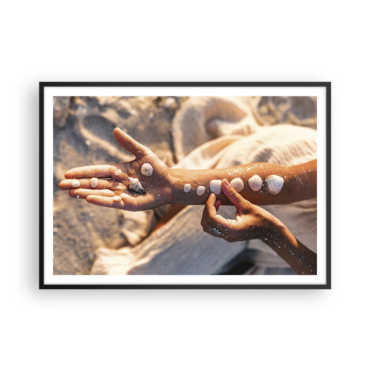 Poster in cornice nera - Mani con conchiglie disposte sullo sfondo di sabbia - 100x70cm - La bellezza a portata di mano - Decorazione murale moderna per soggiorno e camera da letto ARTTOR