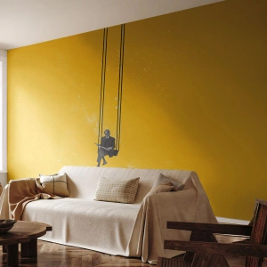 Fotomurali Standard Eco - Una figura in abito su un'altalena su uno sfondo giallo - 100x70cm - Un giorno come tanti - Decorazione murale moderna per soggiorno e camera da letto ARTTOR
