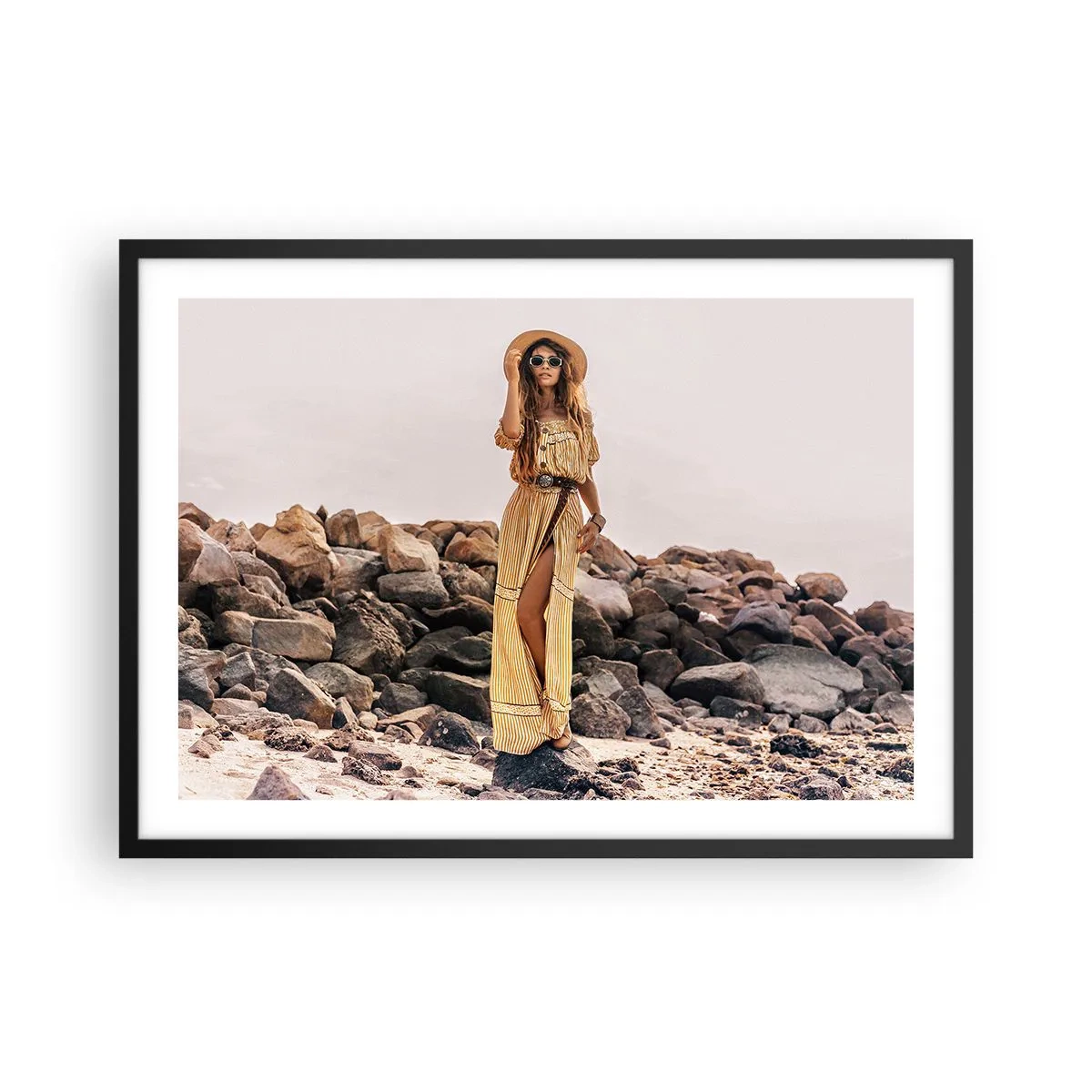 Poster in cornice nera - Una donna in stile boho sullo sfondo di una spiaggia rocciosa - 70x50cm - La magia delle pietre - Decorazione murale moderna per soggiorno e camera da letto ARTTOR