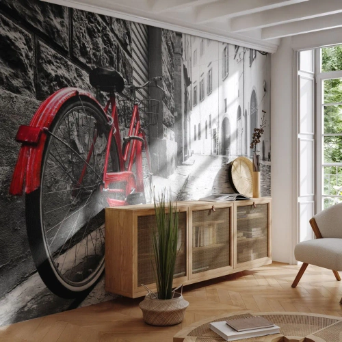 Fotomurali Premium Sand - Una bicicletta rossa su una strada cittadina acciottolata - 100x70cm - La vera bellezza non invecchia - Decorazione murale moderna per soggiorno e camera da letto ARTTOR