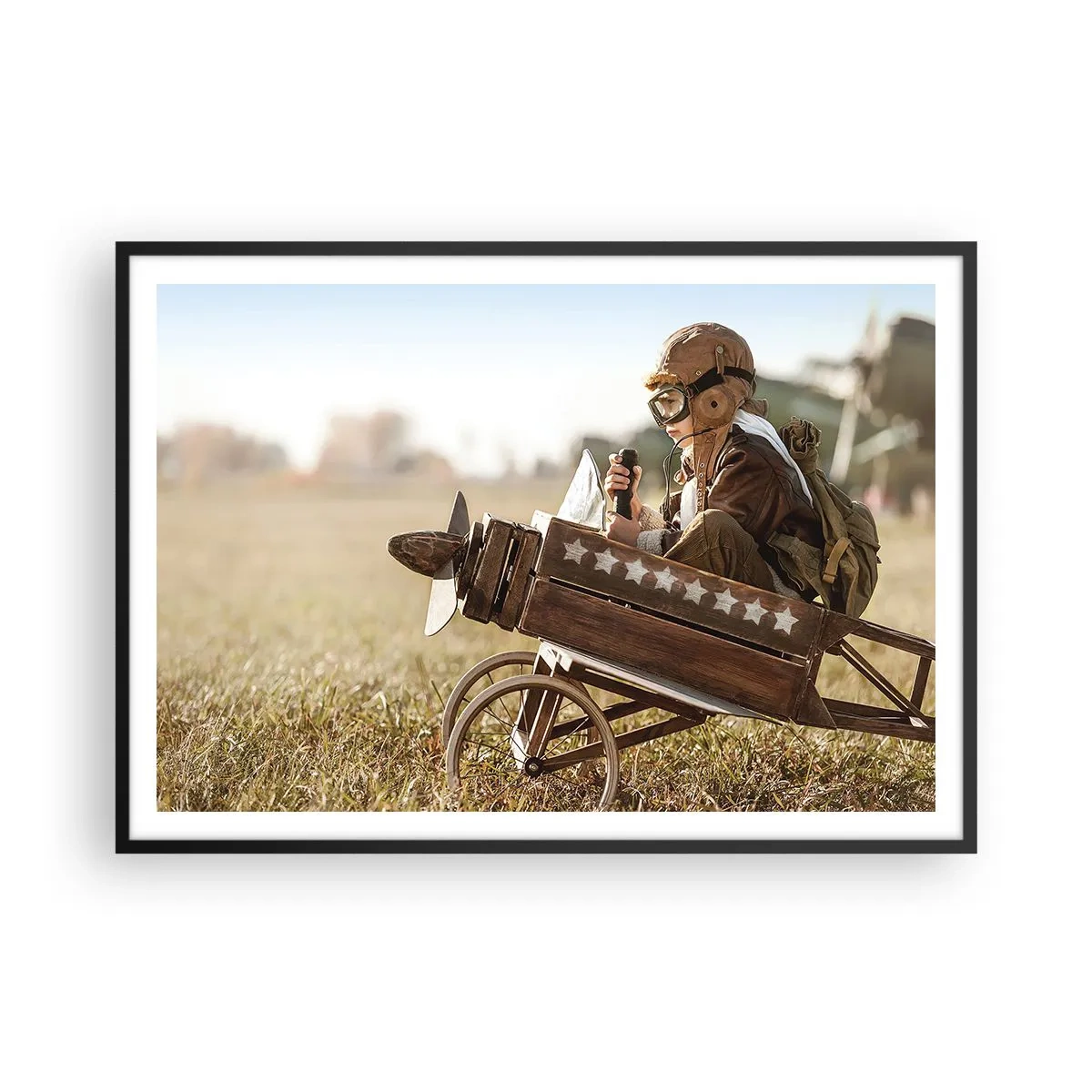 Poster in cornice nera - Un bambino su un aeroplanino giocattolo con un campo sullo sfondo - 100x70cm - Decollo verso i sogni - Decorazione murale moderna per soggiorno e camera da letto ARTTOR